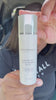 Woman applying Radiant Veil SPF 30 mineral sunscreen outside